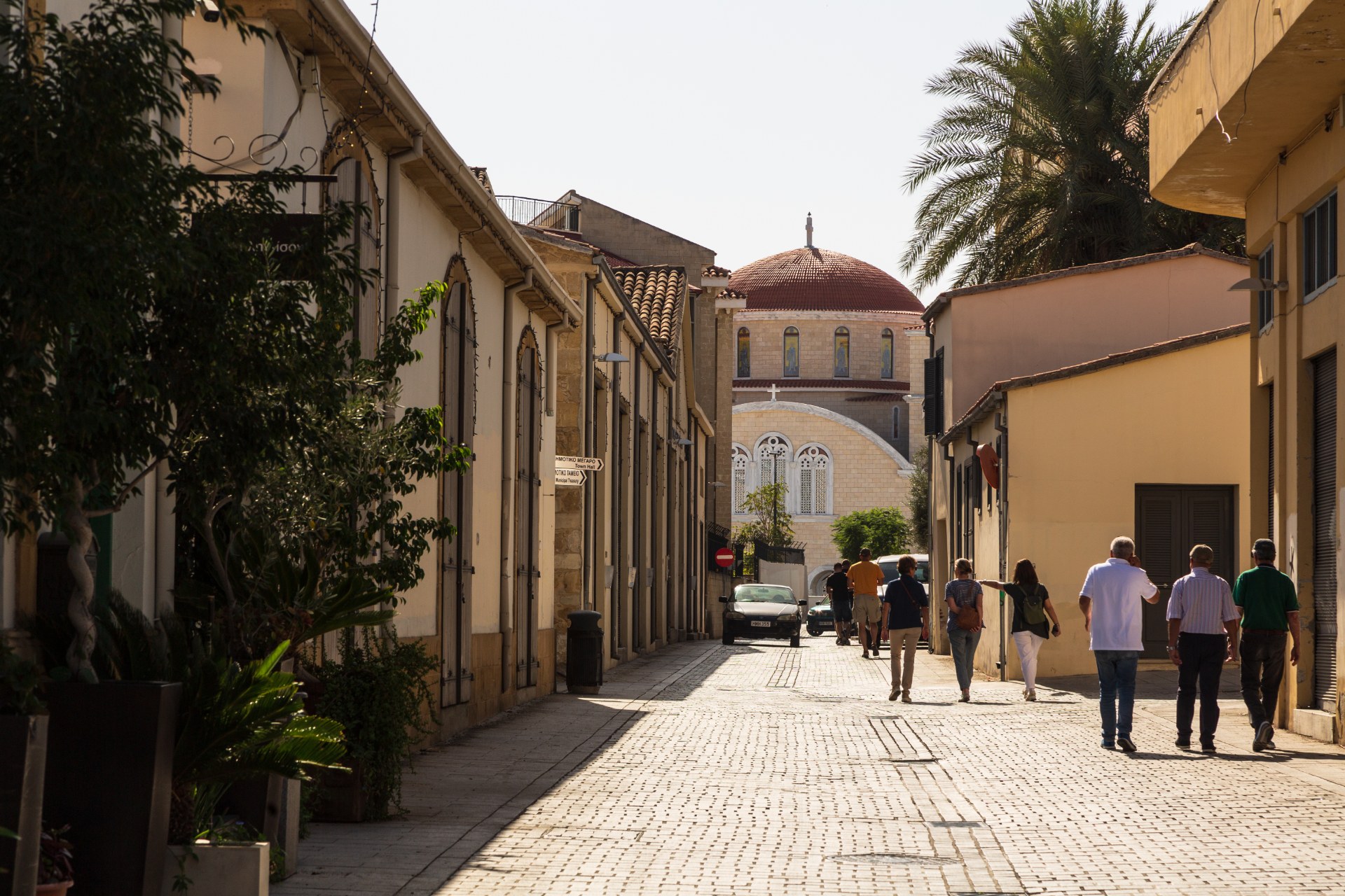 Passants dans une ruelle étroite de la vieille ville de Nicosie, en direction d’une cathédrale à coupole